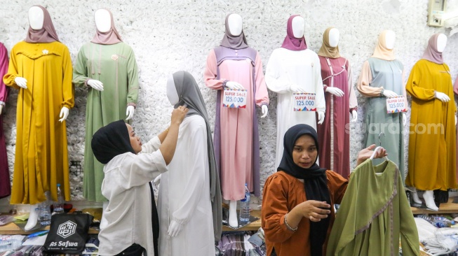 Pengunjung memilih pakaian di Pasar Tanah Abang, Jakarta, Kamis (7/3/2024). [Suara.com/Alfian Winanto]
