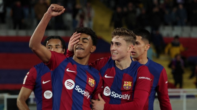 Penyerang Barcelona Spanyol Lamine Yamal (tengah) merayakan kemenangan bersama rekan satu timnya di akhir pertandingan sepak bola liga Spanyol antara FC Barcelona dan RCD Mallorca di Estadi Olimpic Lluis Companys di Barcelona pada 8 Maret 2024.LLUIS GEN / AFP