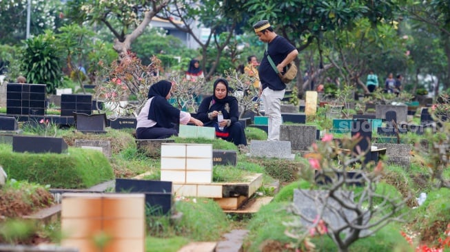 Warga melakukan ziarah kubur di TPU Karet Bivak, Jakarta, Minggu (10/3/2024). [Suara.com/Alfian Winanto]