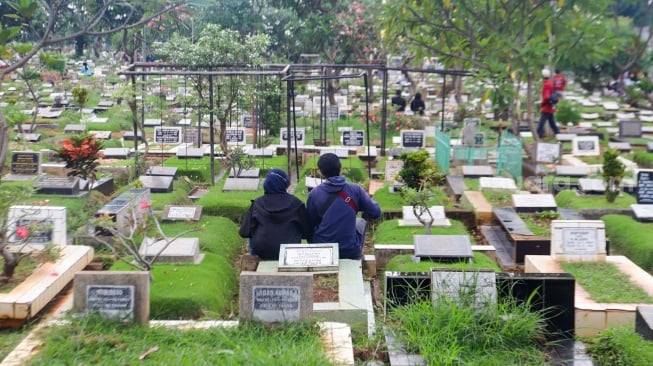 Warga melakukan ziarah kubur di TPU Karet Bivak, Jakarta, Minggu (10/3/2024). [Suara.com/Alfian Winanto]