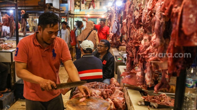 Pedagang memotong daging sapi di Pasar Senen, Jakarta, Senin (11/3/2024). [Suara.com/Alfian Winanto]
