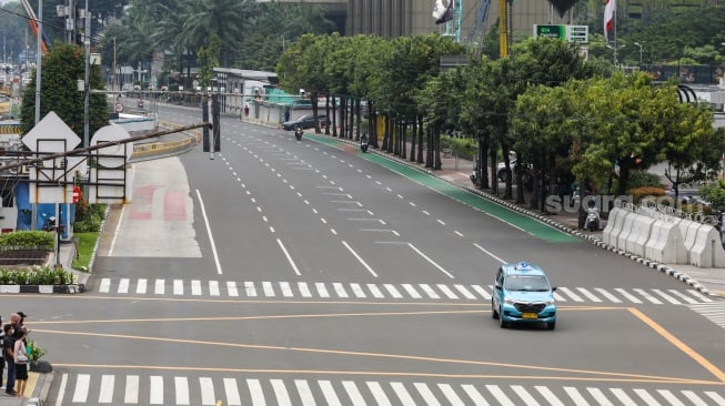 Kendaraan melintas di Jalan MH Thamrin, Jakarta, Selasa (12/3/2024). [Suara.com/Alfian Winanto]