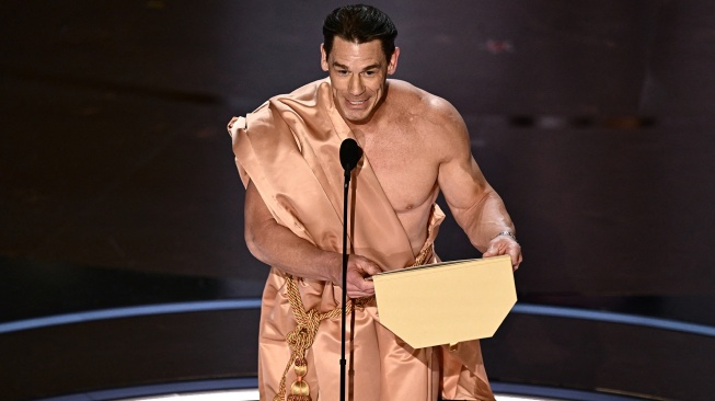 Aktor John Cena saat membacakan penghargaan untuk Desain Kostum Terbaik di atas panggung pada Academy Awards Tahunan ke-96 di Teater Dolby di Hollywood, California, Minggu (10/3/2024).  [Patrick T. Fallon / AFP]