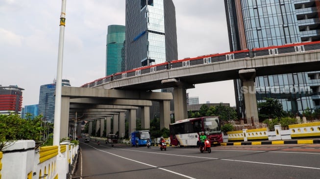 Kendaraan melintas di Jalan MH Kuningan, Jakarta, Selasa (12/3/2024). [Suara.com/Alfian Winanto]