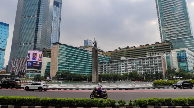 Kendaraan melintas di Bundaran HI, Jakarta, Selasa (12/3/2024). [Suara.com/Alfian Winanto]