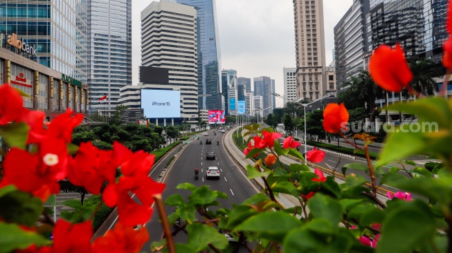 Kendaraan melintas di Jalan Sudirman, Jakarta, Selasa (12/3/2024). [Suara.com/Alfian Winanto]