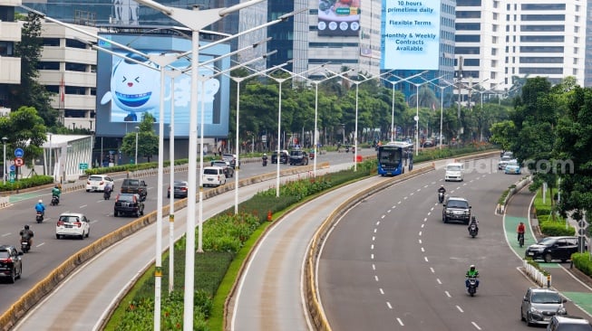 Kendaraan melintas di Jalan Sudirman, Jakarta, Selasa (12/3/2024). [Suara.com/Alfian Winanto]