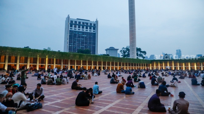 Warga memakan Takjil saat berbuka puasa di Masjid Istiqlal, Jakarta, Selasa (12/3/2024). [Suara.com/Alfian Winanto]