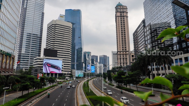 Kendaraan melintas di Jalan Sudirman, Jakarta, Selasa (12/3/2024). [Suara.com/Alfian Winanto]