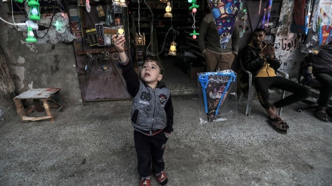 Seorang anak laki-laki melihat lampu hias dan lentera di sebuah toko di Deir al-Balah di Gaza tengah. [AFP]