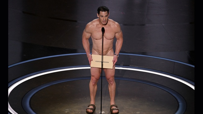 Aktor John Cena saat membacakan penghargaan untuk Desain Kostum Terbaik di atas panggung pada Academy Awards Tahunan ke-96 di Teater Dolby di Hollywood, California, Minggu (10/3/2024).  [Patrick T. Fallon / AFP]