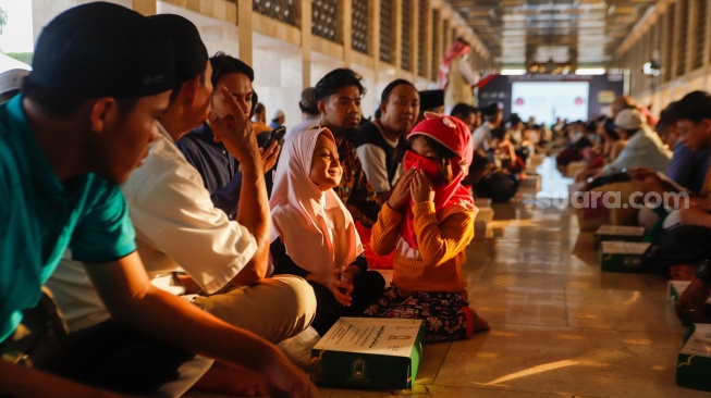 Petugas membagikan menu berbuka puasa di Masjid Istiqlal, Jakarta, Selasa (12/3/2024). [Suara.com/Alfian Winanto]