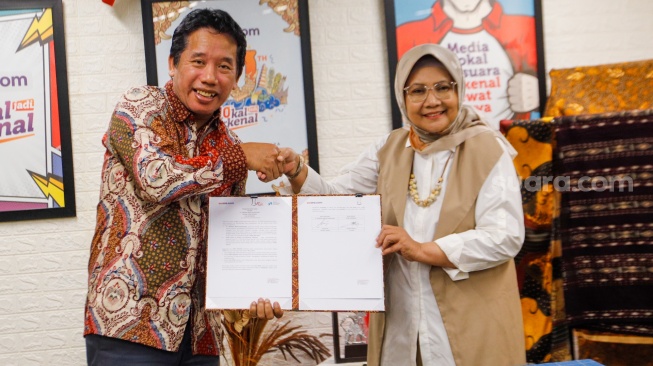 Pemimpin Redaksi Suara.com, Suwarjono (kiri) bersama Founder & Researcher CORE Indonesia, Hendri Saparini (kanan) berjabat tangan usai menandatangani MoU Kerja Sama gelaran Youth Economic Summit 2024 di Kantor Redaksi Suara.com, Kuningan, Jakarta, Rabu (13/3/2024). [Suara.com/Alfian Winanto]