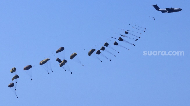 Gambar yang diambil dari perbatasan selatan Israel dengan Jalur Gaza ini menunjukkan sebuah pesawat militer menjatuhkan bantuan kemanusiaan di wilayah Palestina pada Selasa (12/3/2024).  [Menahem KAHANA/AFP] 