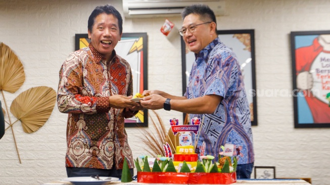 Pemimpin Redaksi Suara.com, Suwarjono (kiri) menerima nasi kuning dari Komisaris Arkadia Digital Media, Iwa Karunia (kanan) saat perayaan 10 Tahun Suara.com di Kantor Redaksi Suara.com, Jakarta, Rabu (13/3/2024). [Suara.com/Alfian Winanto]