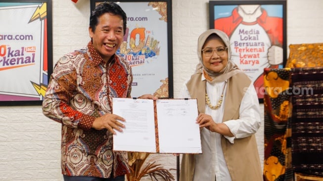 Pemimpin Redaksi Suara.com, Suwarjono (kiri) bersama Founder & Researcher CORE Indonesia, Hendri Saparini (kanan) usai menandatangani MoU Kerja Sama gelaran Youth Economic Summit 2024 di Kantor Redaksi Suara.com, Kuningan, Jakarta, Rabu (13/3/2024). [Suara.com/Alfian Winanto]