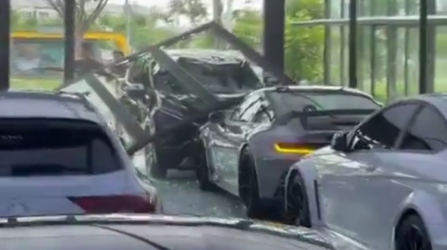 Mobil sport Porsche 911 GT3 RS yang sedang terpakir di sebuah showroom ringsek ditabrak pengemudi mobil Mitsubishi Xpander. (tangkap layar)