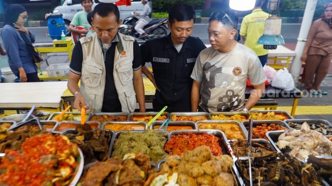 Pengunjung memilih menu berbuka puasa di Sentra kuliner Nasi Kapau di Jalan Kramat Raya, Senen, Jakarta, Kamis (14/3/2024). [Suara.com/Alfian Winanto]