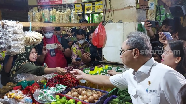 Aksi Borong Mendag Zulhas saat mengunjungi Pasar Kramat Jati, Jakarta Timur, Jumat (15/3/2024)/(Suara.com/Achmad Fauzi).