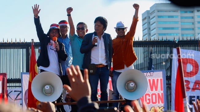 Politisi PDIP sekaligus Anggota DPR, Adian Napitupulu (tengah) menemui pengunjuk rasa saat menggelar aksi di depan Gedung DPR RI, Senayan, Jakarta, Selasa (19/3/2024). [Suara.com/Alfian Winanto]