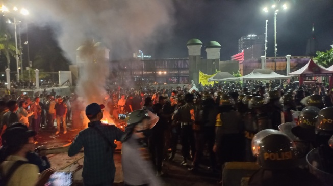 Massa aksi tolak pemilu curang bertahan hingga malam hari di depan Gedung DPR RI, Selasa (19/3/2024). [Suara.com/Faqih]