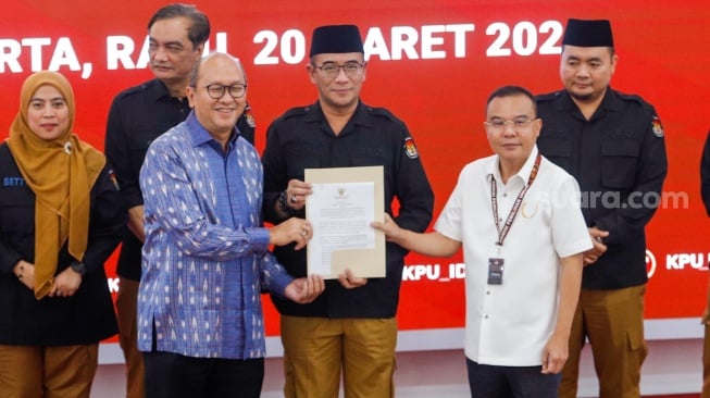 Ketua KPU Hasyim Asy'ari (tengah) menyerahkan Berita Acara Penetapan Hasil Pemilu 2024 kepada saksi Paslon Capres-Cawapres nomor urut dua, saat Rapat Pleno Terbuka Penetapan Hasil Pemilu 2024 Tingkat Nasional di Kantor KPU RI, Jakarta, Rabu (20/3/2024). [Suara.com/Alfian Winanto]