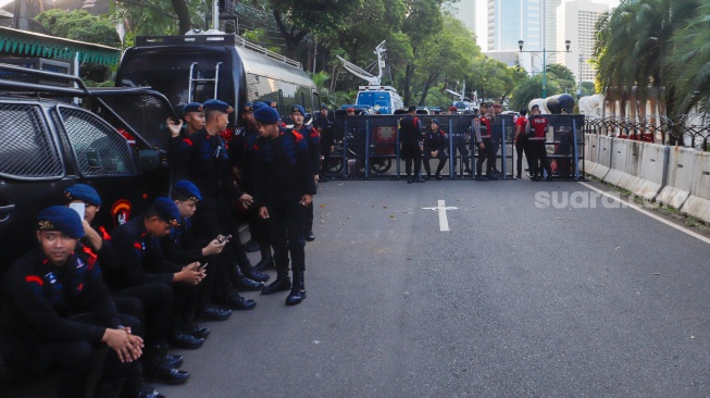 Petugas Kepolisian berjaga di depan Gedung KPU, Jakarta, Rabu (20/3/2024). [Suara.com/Alfian Winanto]