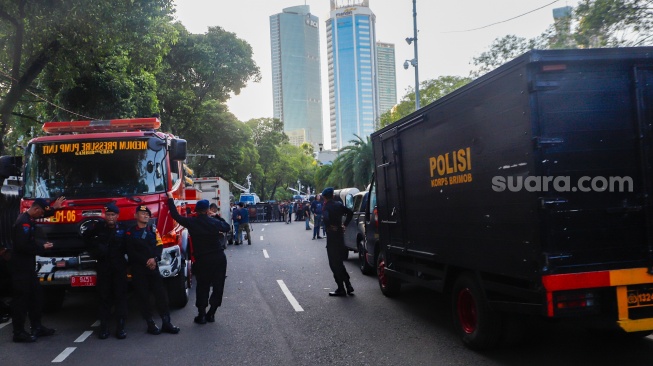 Petugas Kepolisian berjaga di depan Gedung KPU, Jakarta, Rabu (20/3/2024). [Suara.com/Alfian Winanto]