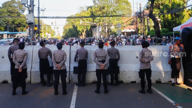 Petugas Kepolisian berjaga di depan Gedung KPU, Jakarta, Rabu (20/3/2024). [Suara.com/Alfian Winanto]