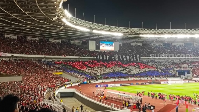 Koreografi suporter Timnas Indonesia yang menampilkan gambar mirip bendera Belanda dalam laga kontra Vietnam di Stadion Utama Gelora Bung Karno (SUGBK), Jakarta, Kamis (21/3/2024) malam WIB. [Suara.com/Arief Apriadi]