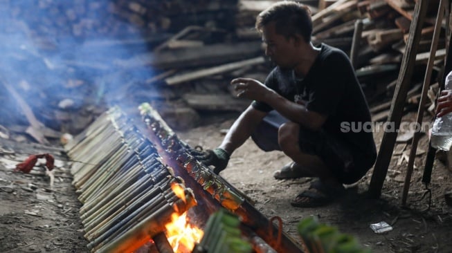 Pekerja menyelesaikan produksi lemang di kawasan Senen, Jakarta, Sabtu (23/3/2024). [Suara.com/Alfian Winanto]