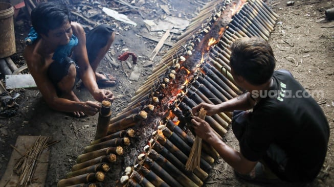 Pekerja menyelesaikan produksi lemang di kawasan Senen, Jakarta, Sabtu (23/3/2024). [Suara.com/Alfian Winanto]