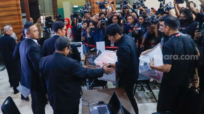 Tim hukum nasional Ganjar Pranowo-Mahfud MD membawa berkas saat melakukan pendaftaran gugatan perselisihan hasil pemilihan umum (PHPU) Presiden dan Wakil Presiden tahun 2024 di gedung Mahkamah Konstitusi, Jakarta, Sabtu (23/3/2024). [Suara.com/Alfian Winanto]