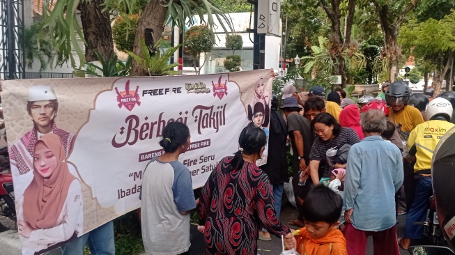 Komunitas Free Fire Soloraya mengisi bulan Ramadan dengan membagikan takjil berbuka puasa di Jalan Slamet Riyadi tepatnya seberang Plasa Sriwedari, Sabtu (23/3/2024). [Suara.com/Ronald Seger Prabowo]