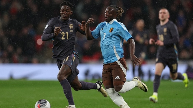 Gelandang Timnas Inggris, Kobbie Mainoo (kiri) tampil dalam laga persahabatan kontra Belgia di Stadion Wembley, London, Rabu (27/3/2024) dini hari WIB. [Adrian DENNIS / AFP]