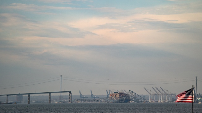 Bagian rangka baja Jembatan Francis Scott Key berada di atas kapal kontainer Dali setelah jembatan tersebut runtuh di Baltimore, Maryland, Amerika Serikat, Selasa (26/3/2024). [AFP]
