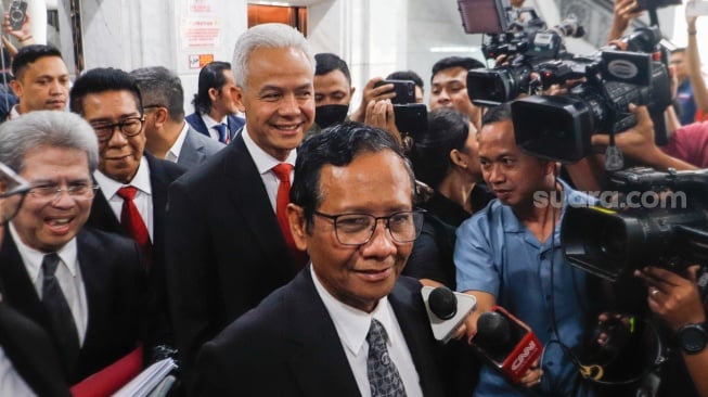 Pasangan Capres-Cawapres nomor urut tiga, Ganjar Pranowo dan Mahfud MD (tengah) saat hadir untuk mengikuti sidang perdana Perselisihan Hasil Pemilu Umum (PHPU) di Gedung Mahkamah Konstitusi, Jakarta, Kamis (27/3/2024). [Suara.com/Alfian Winanto]