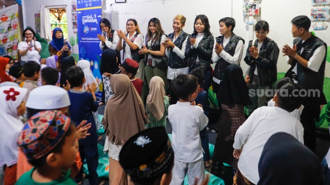 Anggota komunitas Bikers Cegan menghibur anak-anak di acara Takjil Gratis In Friday (TGIF) Suara Hati Ramadan di Sekolah Alternatif untuk Anak Jalanan (SAAJA), Jakarta, Kamis (28/3/2024). [Suara.com/Alfian Winanto]