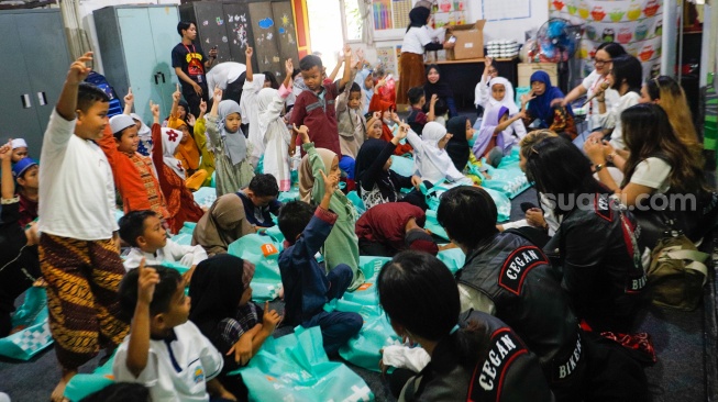 Anggota komunitas Bikers Cegan menghibur anak-anak di acara Takjil Gratis In Friday (TGIF) Suara Hati Ramadan di Sekolah Alternatif untuk Anak Jalanan (SAAJA), Jakarta, Kamis (28/3/2024). [Suara.com/Alfian Winanto]