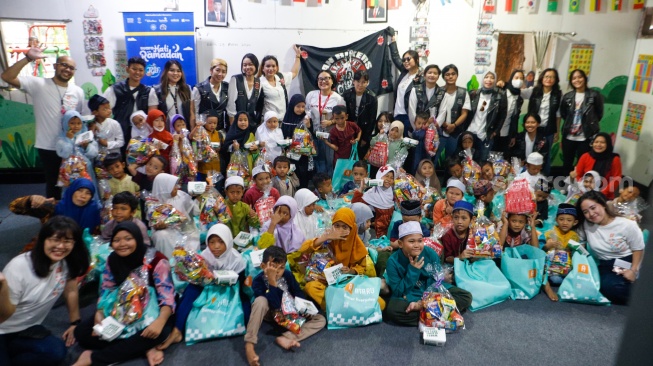 Anggota komunitas Bikers Cegan dan tim dari Suara.com foto bersama anak-anak di acara Takjil Gratis In Friday (TGIF) Suara Hati Ramadan di Sekolah Alternatif untuk Anak Jalanan (SAAJA), Jakarta, Kamis (28/3/2024). [Suara.com/Alfian Winanto]