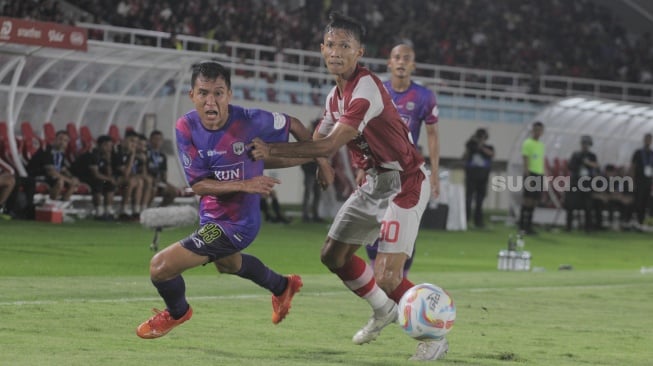 Bek Persis Solo, Eky Taufik Febriyanto mengawal pegerakan pemain RANS Nusantara FC, Erwin Ramdani dalam lanjutan pekan ke-30 BRI Liga 1 2023/2024 di Stadion Manahan, Sabtu (30/3/2024). [Suara.com/Ronald Seger Prabowo]