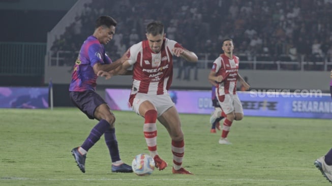 Striker Persis Solo, David Gonzales berusaha melewati kawalan pemain RANS Nusantara FC dalam lanjutan pekan ke-30 BRI Liga 1 2023/2024 di Stadion Manahan, Sabtu (30/3/2024). [Suara.com/Ronald Seger Prabowo]