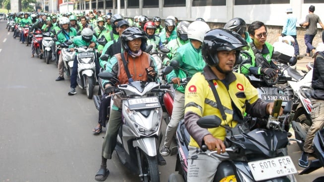 Antrian ojol untuk mendapatkan paket bantuan bahan pangan di depan Gedung Kejaksaan Agung RI, Jakarta, Senin (1/4/2024). [Suara.com/Alfian Winanto]