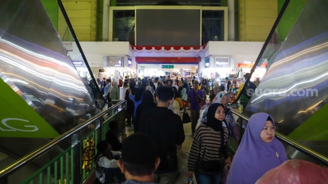 Warga memilih baju lebaran di Pasar Tanah Abang, Jakarta, Senin (1/4/2024). [Suara.com/Alfian Winanto]