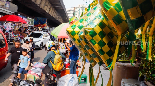 Aktivitas pembeli saat melihat pernak-pernik Ramadhan dan Lebaran di Pasar Asemka, Jakarta, Selasa (2/4/2024). [Suara.com/Alfian Winanto]