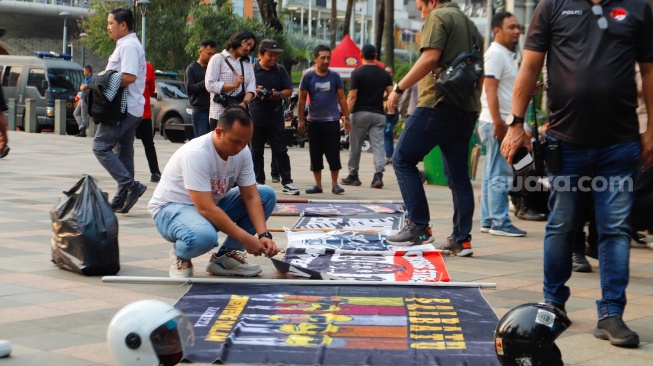 Petugas mengamankan anak-anak saat Razia konvoi kendaraan bermotor di Bundaran HI, Jakarta, Selasa (2/4/2024). [Suara.com/Alfian Winanto]