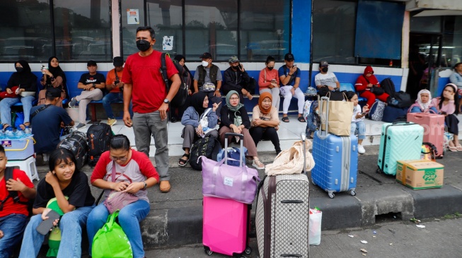 Calon Pemudik menunggu kedatangan bus di Terminal Kampung Rambutan, Jakarta, Sabtu (6/4/2024). [Suara.com/Alfian Winanto]