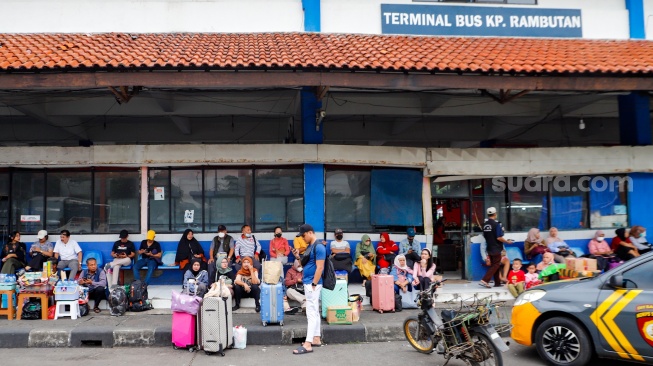 Calon Pemudik menunggu kedatangan bus di Terminal Kampung Rambutan, Jakarta, Sabtu (6/4/2024). [Suara.com/Alfian Winanto]