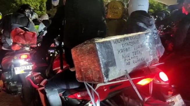 Pemudik motor menuliskan kata-kata unik yang berisi ia tetap pulang meski takut ditanya kapan nikah. [Yandi Sofyan/Suara.com]