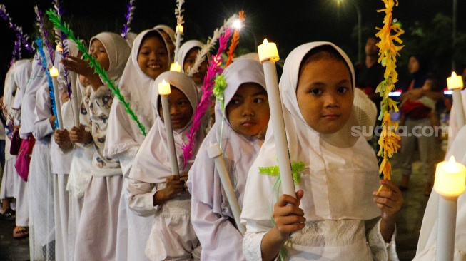 Sejumlah warga melakukan pawai obor malam takbiran di kawasan Masjid Istiqlal, Jakarta, Selasa (9/4/2024). [Suara.com/Alfian Winanto]